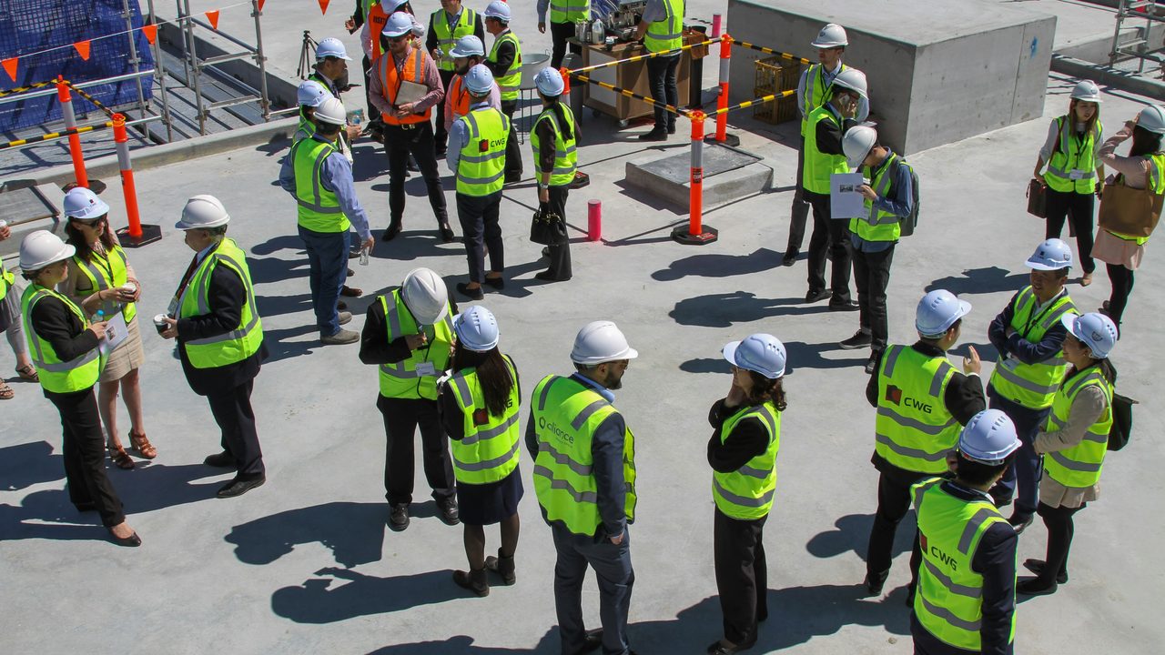 A large group in hi-vis vests and hard hats gathered for a site briefing